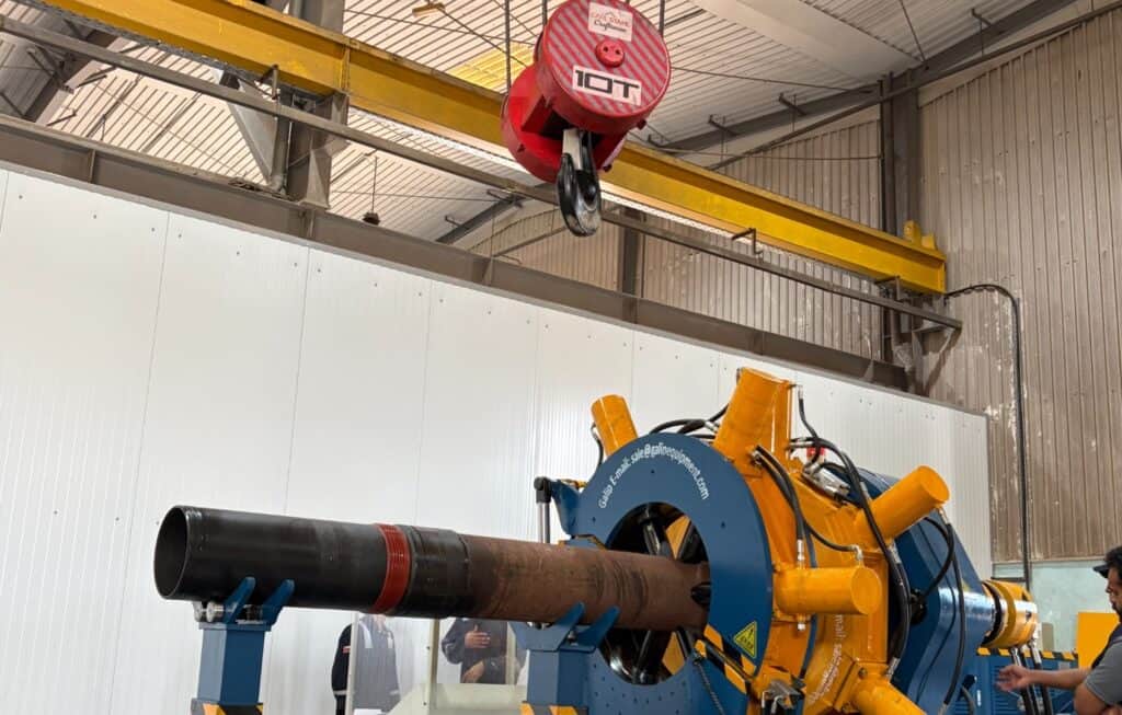 Oilfield drilling torque tool with casing pipe in industrial setting.