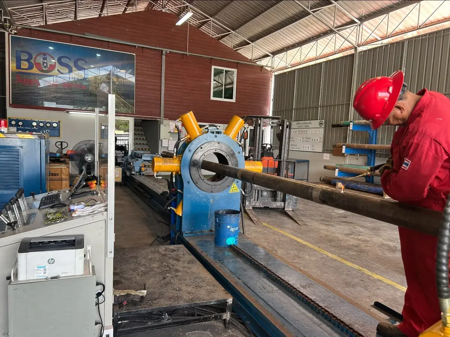 Technician applying heat to a thread-locked connection before break-out on a Galip breakout unit in a customer workshop